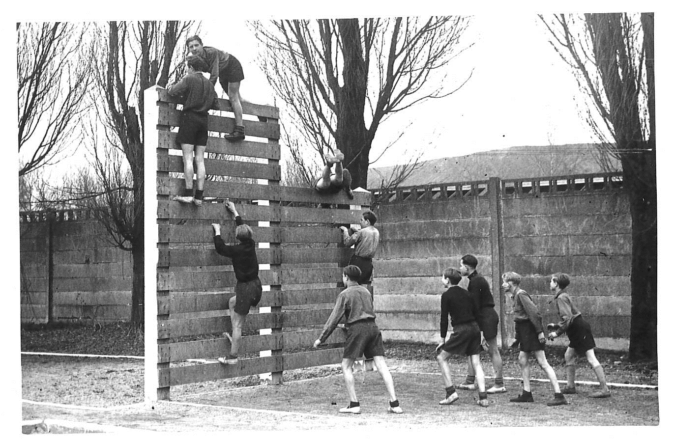 Jeune escaladant un mur en bois